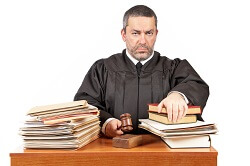 Angry male judge in a courtroom striking the gavel and pronounces sentence
